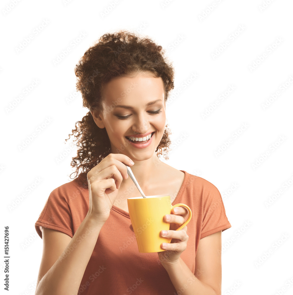 Young beautiful woman with yellow cup of coffee and spoon on white background