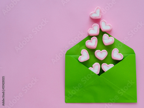 Love letter valentine's day concept. Closeup image of blue letter with copy space arranged on pink background  and colorful of hearts photo