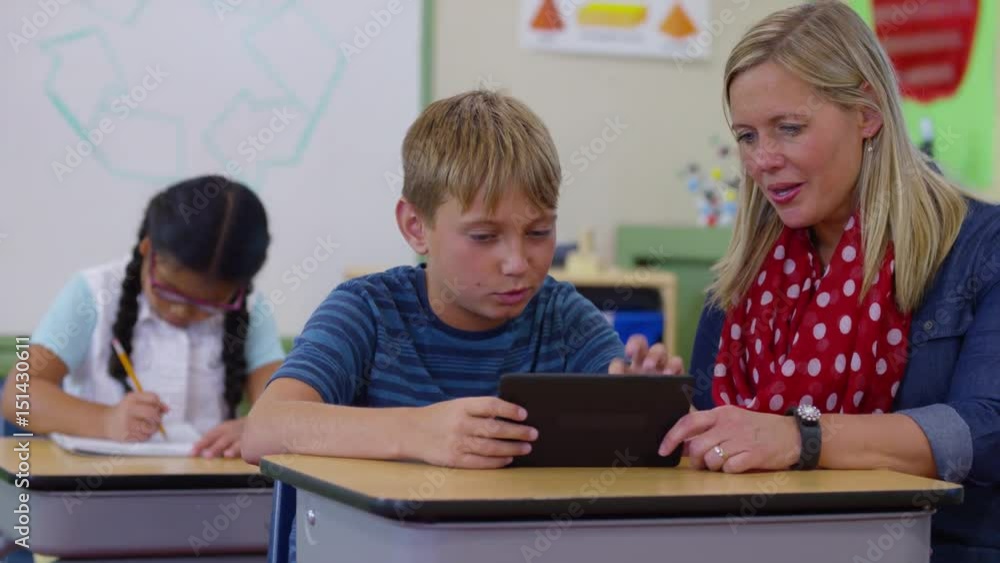 Teacher and student using digital tablet in school classroom Teacher and student using digital tablet in school classroom