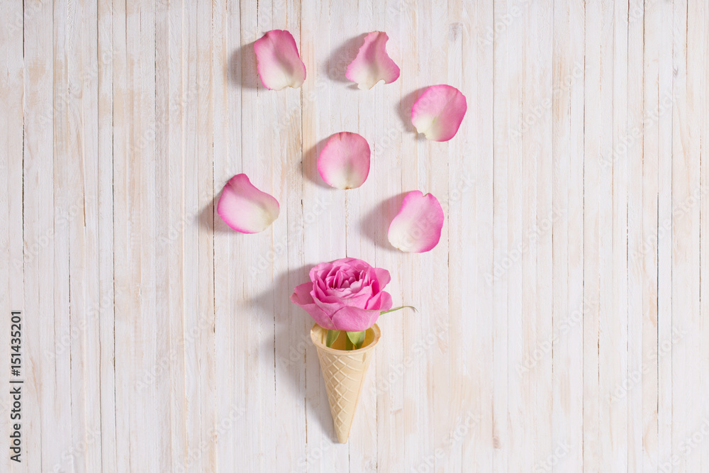 Flowers in a waffle cone on white wooden background