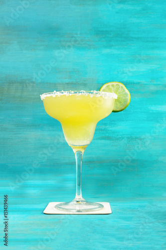Lemon Margarita cocktail on vibrant turquoise with copyspace