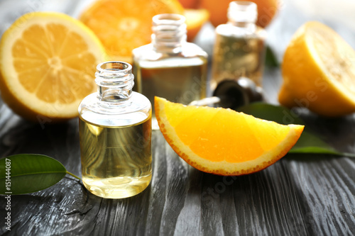 Beautiful composition with perfume bottles and citrus fruits on wooden background photo