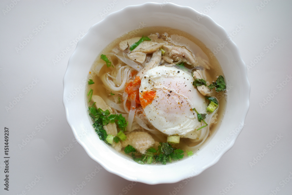 Bowl of vietnamese chicken pho with an poached egg. Pho ga with egg. Rice noodle soup. Bowl of vietnamese chicken pho with an poached egg. Pho ga with egg. Rice noodle soup.