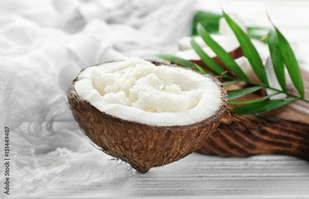 Fresh coconut oil in half of nut on wooden table Fresh coconut oil in half of nut on wooden table