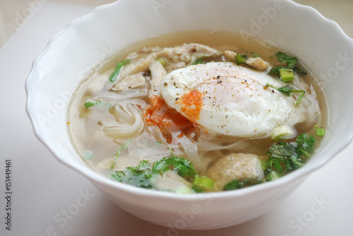Bowl of vietnamese chicken pho with an poached egg. Pho ga with egg. Rice noodle soup.