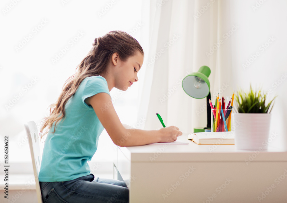 happy girl with book writing to notebook at home happy girl with book writing to notebook at home