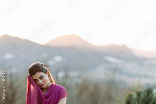 Woman in pink dress with mountain view at sunset