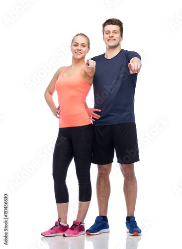 happy sportive man and woman pointing finger