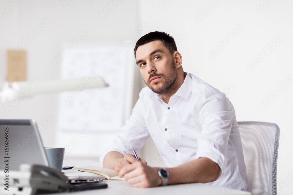 businessman with laptop and notebook at office