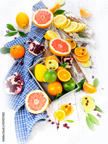 Fresh citrus fruits on a white wooden board.