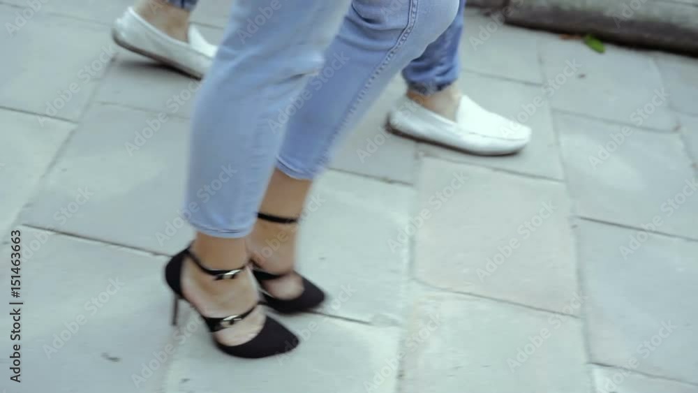 Romantic couple feet go away on the street. Slowly Romantic couple feet go away on the street. Slowly