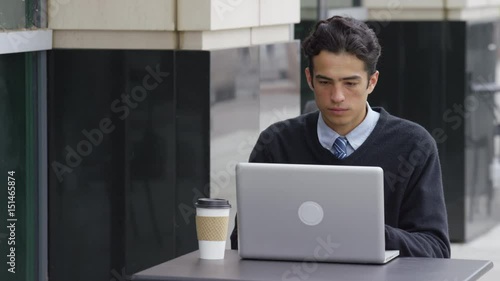 Young businessman using laptop computer at outdoorcafe photo