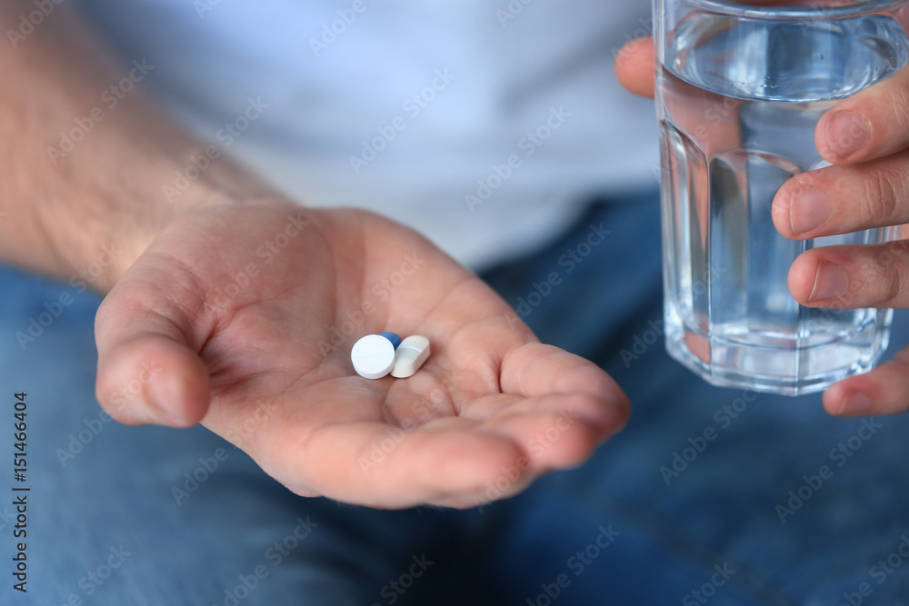 Male hands with pills and glass of water, closeup Male hands with pills and glass of water, closeup
