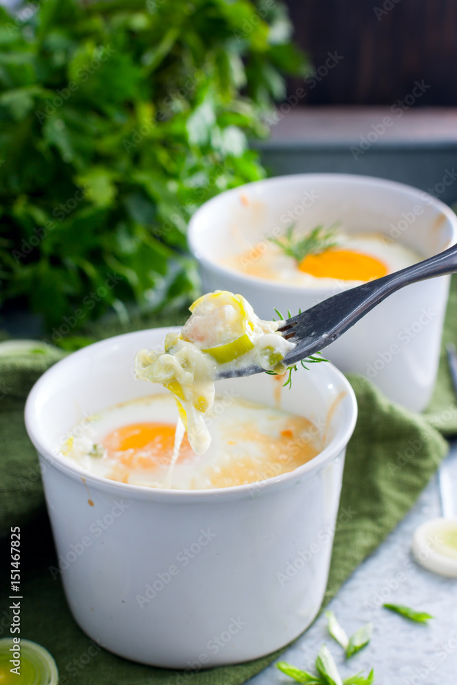 Breakfast with eggs baked with onion in porridge bowls, selective focus