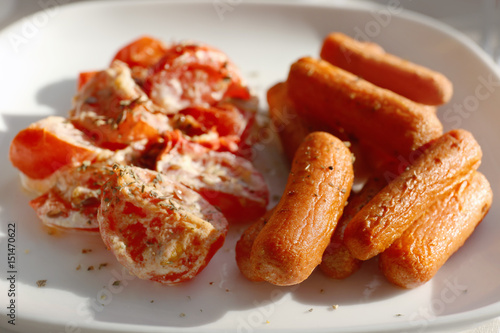 Plate with fried carrot and tomatoes, closeup