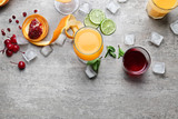 Glasses of Tequila Sunrise cocktail and ingredients on grey background