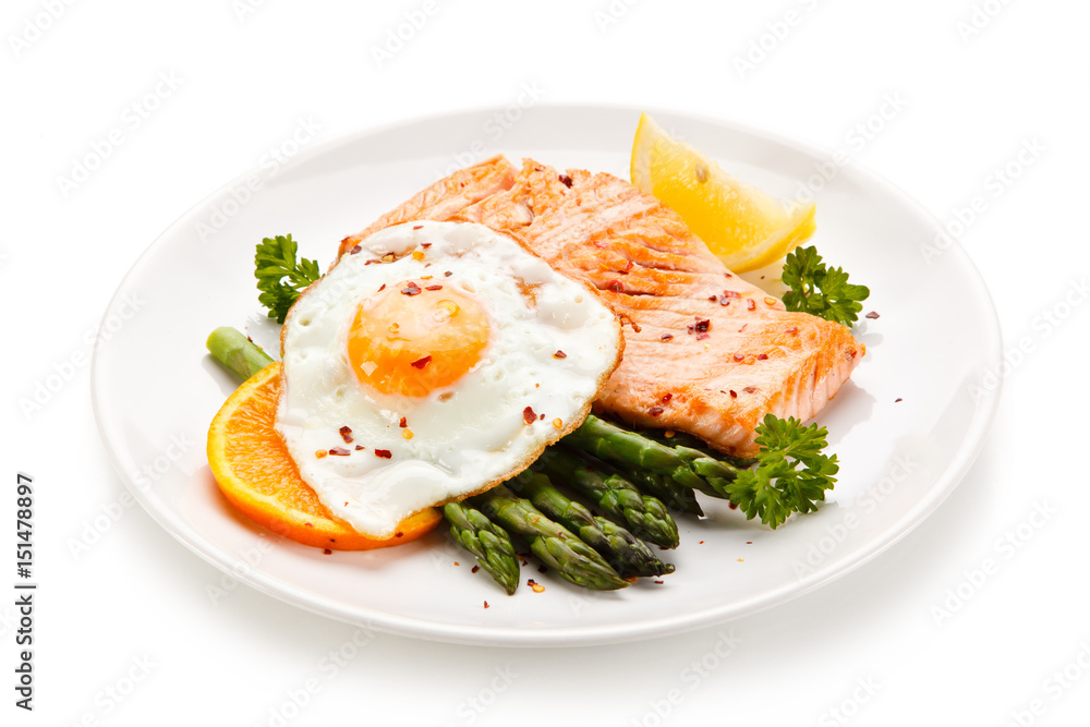 Griilled salmon with asparagus and fried egg on white background Griilled salmon with asparagus and fried egg on white background