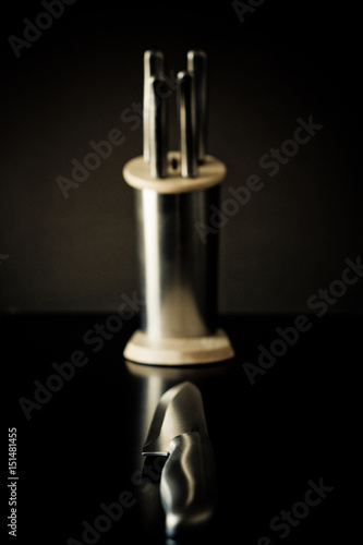 Kitchen knives set against dark brown background