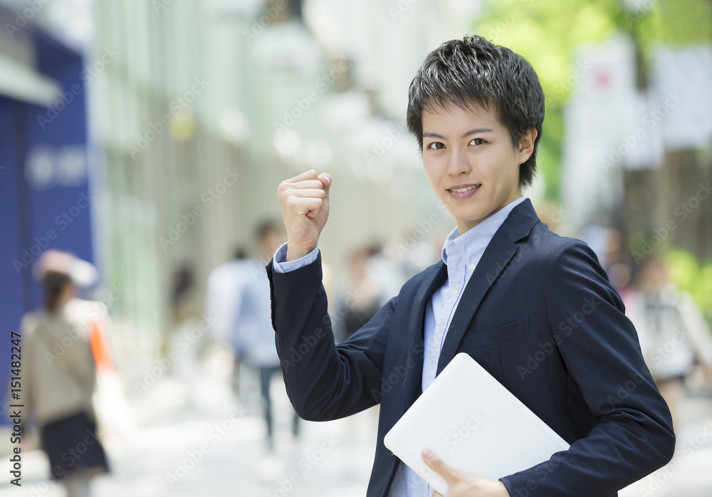ノートPCを持ったビジネスカジュアルの男性　ガッツポーズ　東京表参道 IT系イメージ