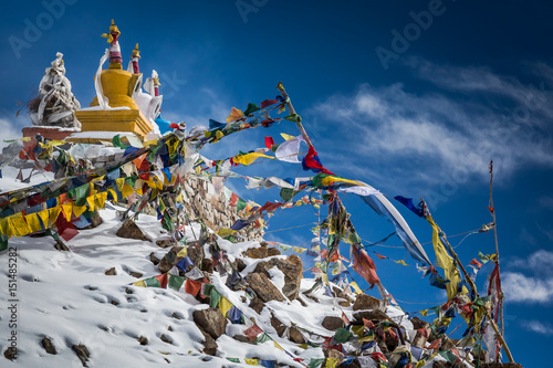 Colourful Buddhist religious stupas and prayer flags at Khardung La pass, the highest (5,359 m, 17,582 ft) motorable pass on the world. Ladakh, Jammu and Kashmir, India photo