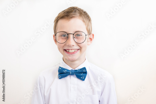 Smiling boy with glasses in white shirt with butterfly on a white background