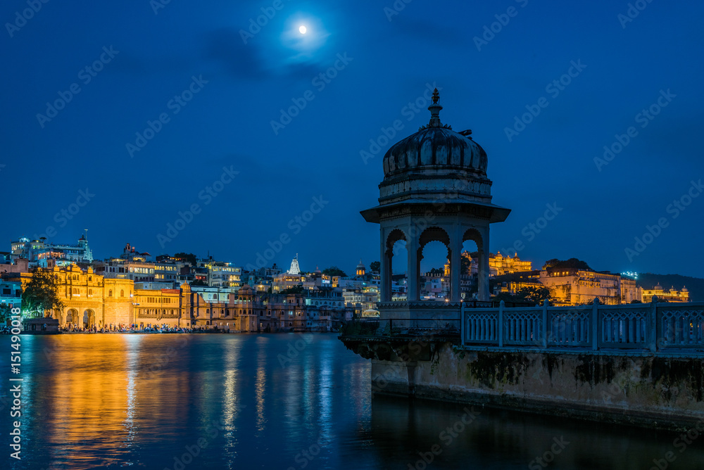 Udaipur's Gangaur Ghat seen under the backdrop of a chattri and a moonlit night on the banks of Lake Pichola.