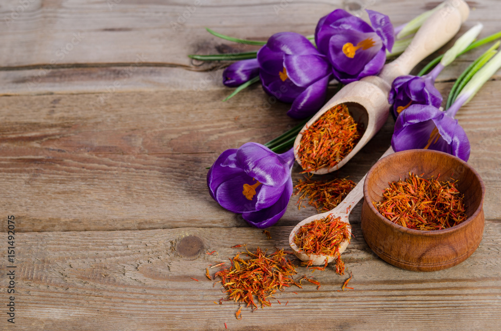 crocus flowers and spoon with soffron on wooden table crocus flowers and spoon with soffron on wooden table