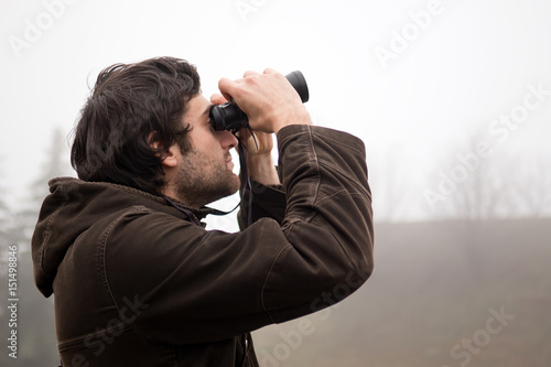 Guy looking at binoculars