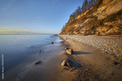 Sunrise over the sea. Beautiful long exposure landscape of rocky shore. Vinta...
