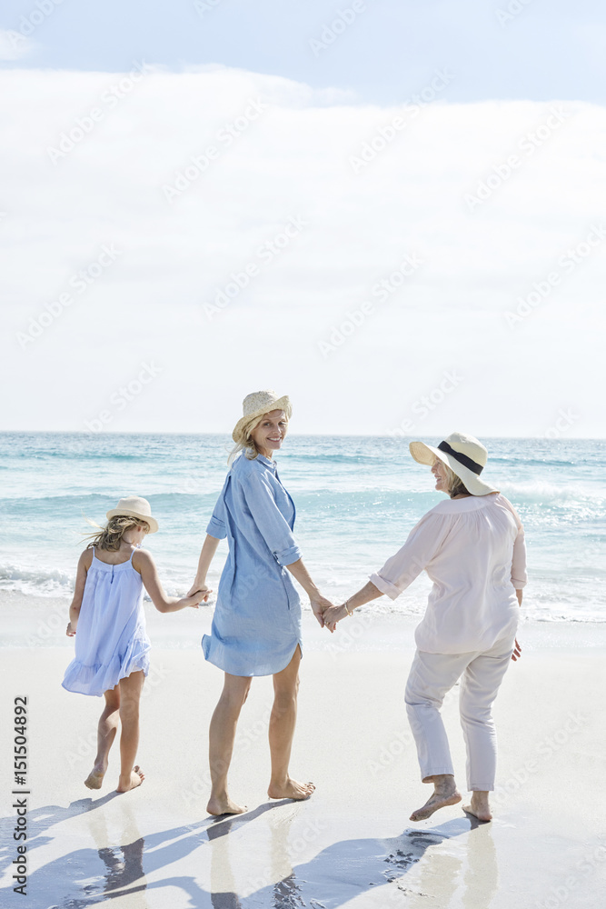 Mother, daughter and grandmother walking by the sea, rear view Mother, daughter and grandmother walking by the sea, rear view