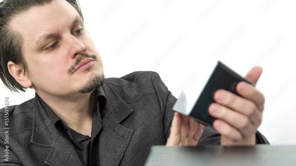 A young worker looks at the time and then he feels upset about it. He places it back on the desk. A young worker looks at the time and then he feels upset about it. He places it back on the desk.