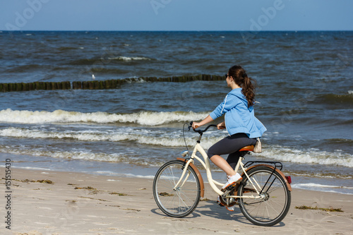 Teenage girl biking on beach