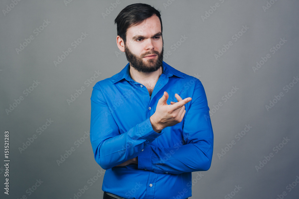 unshaved handsome man in blue shirt on grey wall unshaved handsome man in blue shirt on grey wall