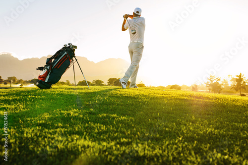 Professional golfer taking shot on golf course