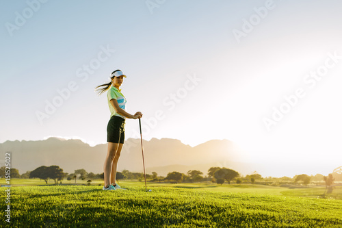 Female golfer standing on golf course