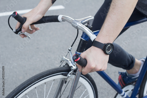 close up picture of mans hand on bicycle bars, man hands with black watches, blue classic bicycle