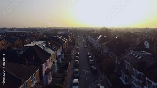 Flying above London surburban houses and apartments aerial view at dawn on sunny day