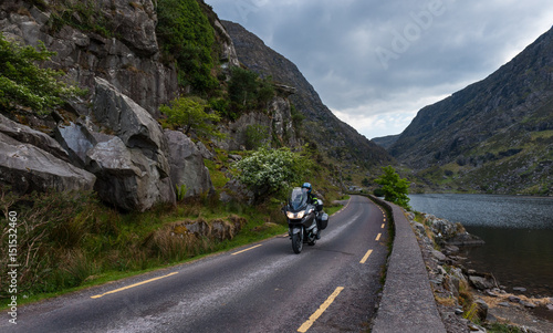 Motorcyclist driving through the winding roads of the gap of Dunloe in county Kerry, Ireland