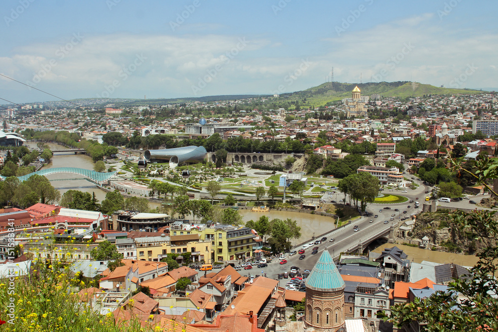 Spring view to historical part of the capital of Republic of Georgia. In the middle river Kura, Bridge of Peace. View from the Fortress Narikala