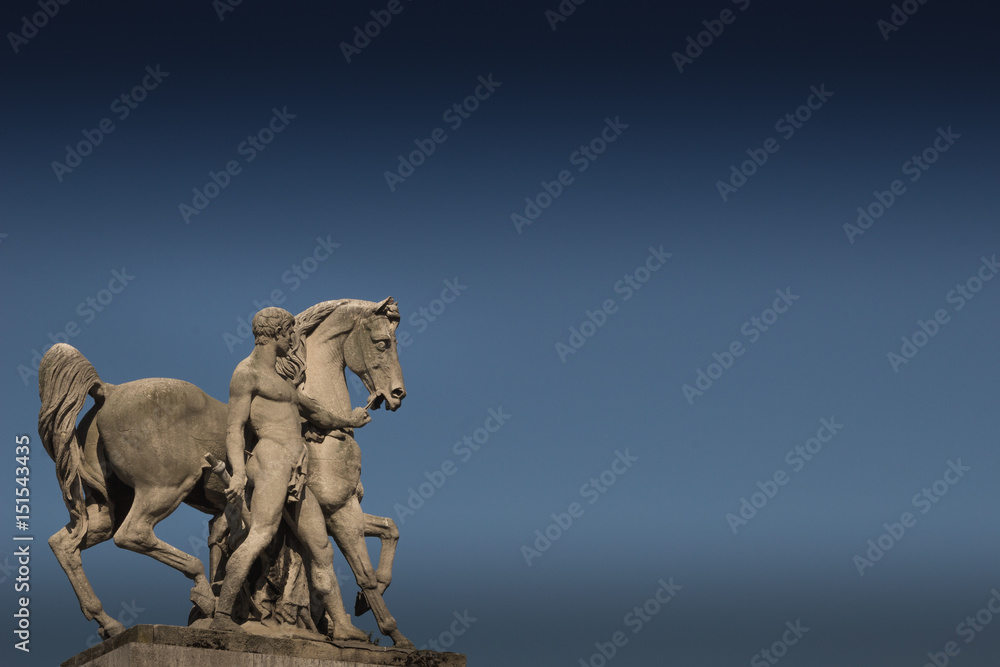 Statue of a Man and Horse in Paris.  Blue background with copy space