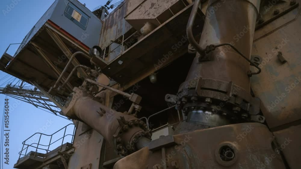 Handheld PAN shot of base and cabin of dragline excavator.