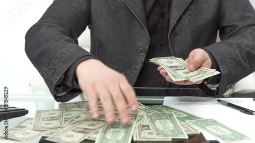 Wallpaper Mural A young man is taking random banknotes into his hand and then is nicely organizing them in his hand. He was calculating the money on his desk. Torontodigital.ca