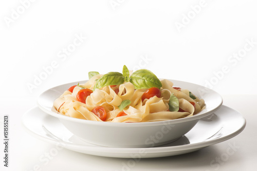 dish with tagliatelle and tomatoes on the white background