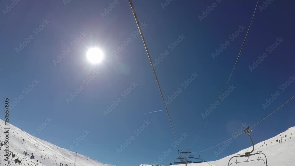 Raised in a ski lift in winter, the sun is shining and flies the plane. Raised in a ski lift in winter, the sun is shining and flies the plane.