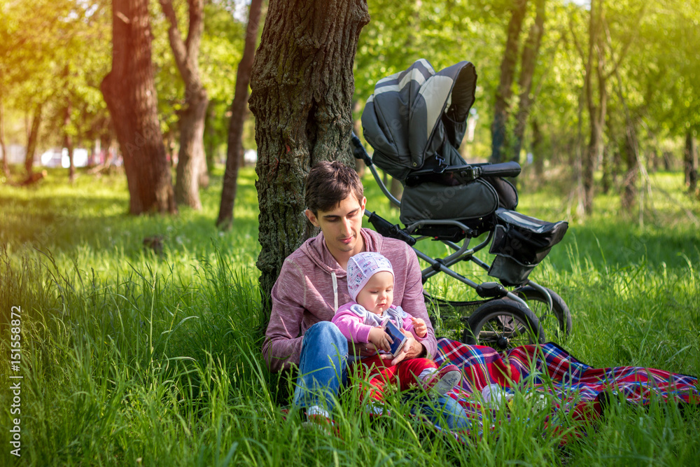 Young father with baby outdoors in park Young father with baby outdoors in park