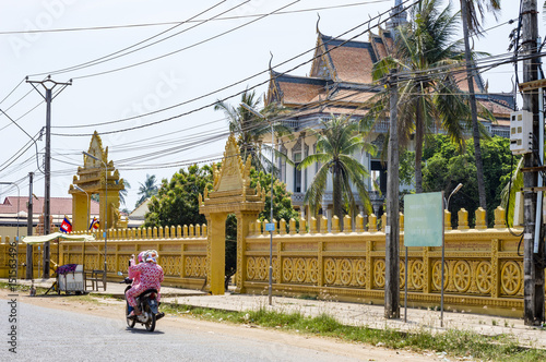 Vászonkép Street view in Cambodia - two women driving motorbike on the street near Buddhis