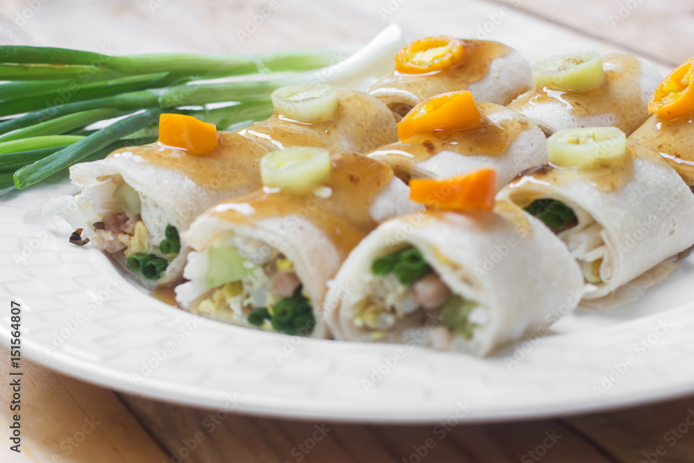 Fresh spring rolls and vegetables eaten on wooden table. Fresh spring rolls and vegetables eaten on wooden table.