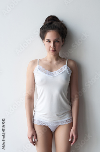 cute girl in white shirt and pantie stand near white wall