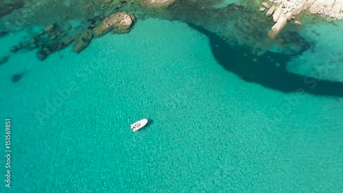 Drone fly over sardinia coastline and colorful turquoise mediterranean sea surraunded by high cliff and ancient ruins of a watchtower