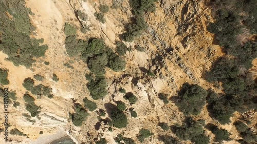 Drone fly over sardinia coastline and colorful turquoise mediterranean sea surraunded by high cliff and ancient ruins of a watchtower